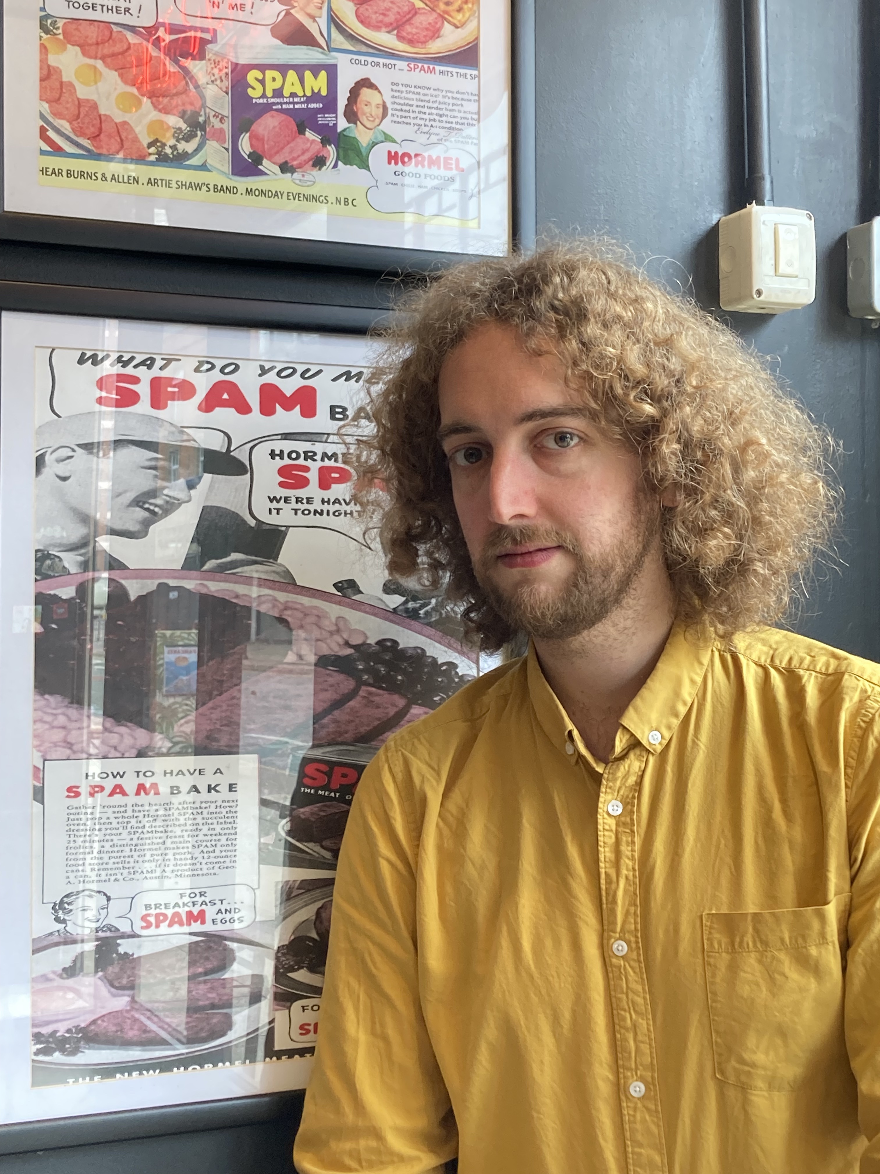 James in front of a SPAM poster.